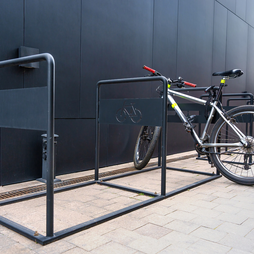 Rower zaparkowany w stojaku rowerowym przy budynku - zewnętrzne stojaki rowerowe