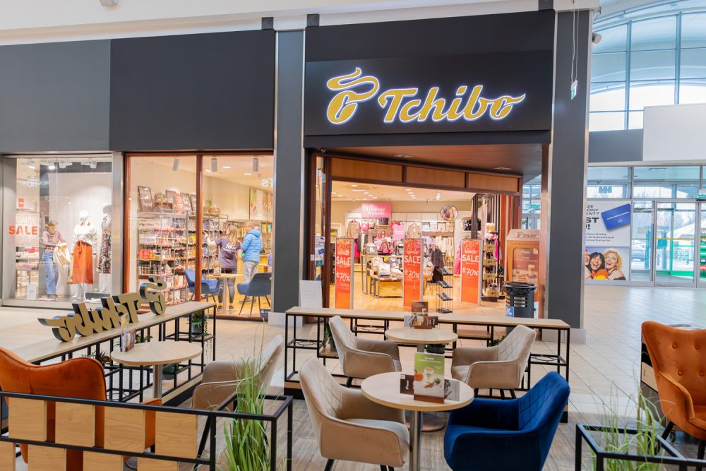 Witryna sklepu Tchibo w M1 Kraków i stoliki przed wejściem